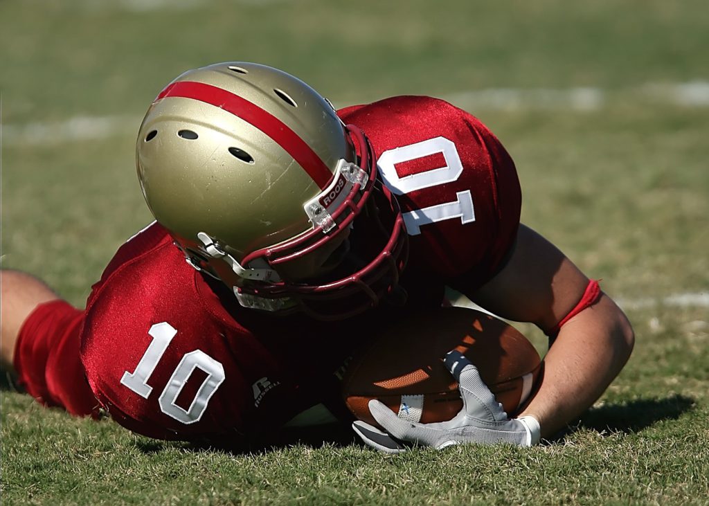 american football player diving and hurting his ACJ