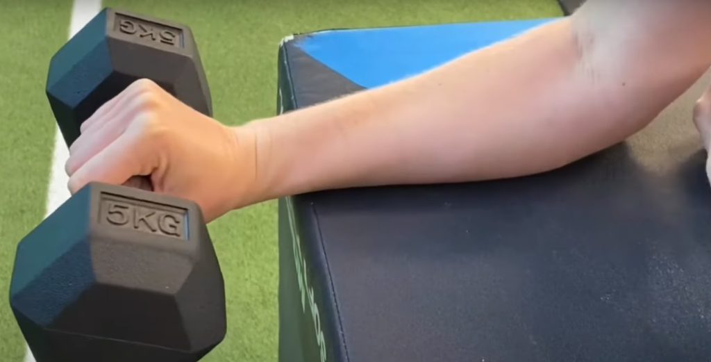 patient holding onto dumbbell ready for exercise